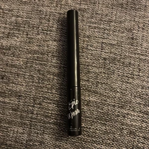 Svart flytande eyeliner från NYX Epic Wear - Säljer en svart flytande eyeliner från NYX Epic Wear. Pennan har en smal och precis applikator som gör det enkelt att skapa både tunna och dramatiska linjer. Perfekt för att framhäva ögonen med en intensiv svart färg.