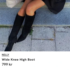 Svarta knähöga boots från Nelly - Säljer ett par svarta knähöga boots från Nelly med bred passform. Skorna har en hög klack och är tillverkade i ett mjukt material med spetsig tå.  Inköpta i våras ensast använda 1 gång 