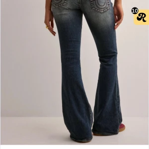Blå bootcut jeans från True Religion - (Pris kan diskuteras!)Säljer ett par klassiska blå bootcut jeans från True Religion med röda sömmar och tydliga bakfickor. Jeansen har normal passform och är tillverkade i denim med snygg tvätt. Perfekta för dig som gillar den trendiga bootcut looken med snygga detaljer!💕
