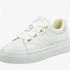 Vita sneakers från Gant AVONA - Säljer ett par stilrena vita sneakers från Gant med breda vita snören och guldfärgade öljetter. Aldrig använda, endast testade. Kvitto finns kvar + paketet. 