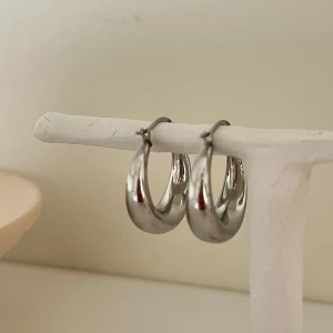 Silverfärgade chunky hoops örhängen - Säljer ett par stilrena och chunky hoops örhängen i silverfärg. De har en rund och tjock design som ger ett modernt och trendigt intryck. Perfekta för att lyfta vilken outfit som helst.