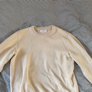 Beige stickad tröja från Les Deux - Säljer en stilren beige stickad tröja från Les Deux. Tröjan har rund halsringning och långa ärmar, perfekt för lager-på-lager eller som den är. Enkel och klassisk design som passar till mycket.[Använd max 10gånger] Stor för S