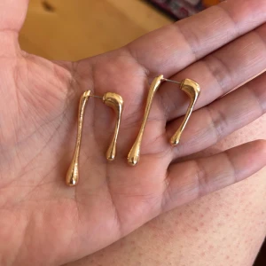 Guld- och silverfärgade droppformade örhängen - Säljer två par stilrena örhängen i droppform, ett par i guld färg .  De har en unik, modern och cool look. Perfekta för att lyfta vilken outfit som helst! Från Asos följ mig ❤️, titta gärna min profil 🤗🤗