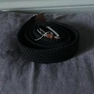 Onewear flätat bälte svart - Tjenare! Säljer ett svart flätat bälte med silverfärgat spänne och detaljer i brunt skinn från onewear. Bältet har en klassisk design och passar till många olika outfits. Perfekt accessoar för att lyfta din stil. Ganska slitet så säljer väldigt billigt!