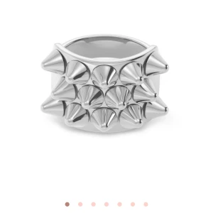 Silverfärgad ring med nitar - Cool och unik ring i silverfärgat material med stora, spetsiga nitar runt hela ringen. Perfekt statement-piece för dig som vill sticka ut och addera edge till din stil.