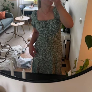 Grön blommig klänning med volang - Helt ny aldrig använd. Pris kan diskuteras
