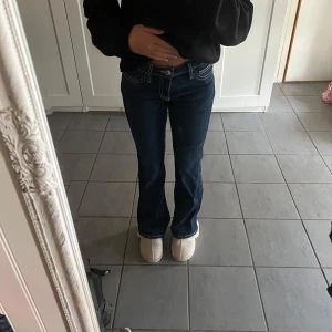 Mörkblå bootcut jeans med kontrastsömmar - Mörkblåa jeans med bootcut passform från Gina Tricot. Dom har tydliga vita kontrastsömmar där bak, låg midja och är aldrig använda. Jag är 157 och storleken är 158💕