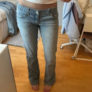bootcut jeans ljusblå - Säljer ett par ljusblå bootcut jeans  med klassisk femficksdesign och broderade bakfickor. Jeansen har låg midja och är tillverkade i mjukt denimtyg som sitter snyggt över höfterna. Perfekta för dig som gillar en avslappnad men trendig look. Midjemått: 36 cm tvärsöver, innerben: 83 cm. Insydda och lagade i skrevet, skriv för bild❤️