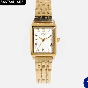 Guldig fyrkantig klocka från Regal - Stilren klocka från Regal med fyrkantig urtavla i vitt och romerska siffror. Armbandet är i guldtonad metall med klassisk länkdesign. Perfekt accessoar för dig som gillar guld och smycken!