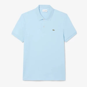 Ljusblå pikétröja från Lacoste - Snygg ljusblå pikétröja från Lacoste med klassisk krage och två knappar framtill. Ikoniska krokodilloggan broderad på bröstet. Tröjan är i mjuk bomull och har korta ärmar, perfekt för en fräsch och clean stil.Om du behöver en annan storlek kan du kolla min profil.  