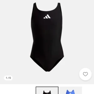 Svart baddräkt från Adidas - En stilren svart baddräkt från Adidas med klassisk vit logga framtill. Modellen har breda axelband och en sportig, enkel design som passar perfekt för simträning eller strandhäng. Materialet är snabbtorkande och stretchigt för bästa komfort.