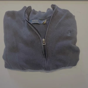 Mörkblå kofta från Polo Ralph Lauren - Snygg mörkblå kofta från Polo Ralph Lauren med hel dragkedja framtill och diskret broderad logga på bröstet. Tröjan är i bomull och har ribbade muddar vid ärmslut och midja. Perfekt för lager-på-lager och chill stil. Vi kan diskutera priset vid en snabb och smidig affär. Skriv vid minsta fundering. Ny pris ligger runt 2000.
