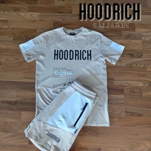 Beige Hoodrich Set - Hoodrich Set – Storlek S – Nyskick Säljer Hoodrich set i S, T-shirt + shorts. Beige med svarta tryck, detaljer fram och bak. Shorts med fickor och dragkedja. Mjukt, bekvämt material – perfekt för streetwear och sommar. Nyskick, aldrig använt utomhus. 📦 Skickas samma dag! 📌 Kontakta vid frågor.