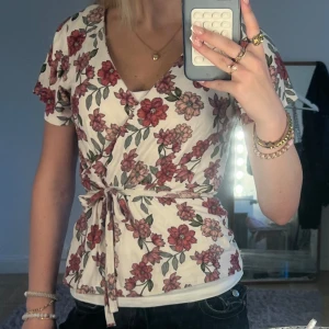 Blommig omlottopp från Indiska - Supersöt omlottopp från Indiska med blommigt mönster storlek xs (den är stor i storleken )