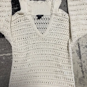 Vit stickad tröja med v-ringning från Lindex - Säljer en vit stickad tröja från Lindex i storlek XS. Tröjan har v-ringning, lång ärm och ett luftigt hålmönster som ger en cool och avslappnad vibe. Perfekt för lager-på-lager och funkar året runt. Snygg ribbad kant vid hals och ärmslut.