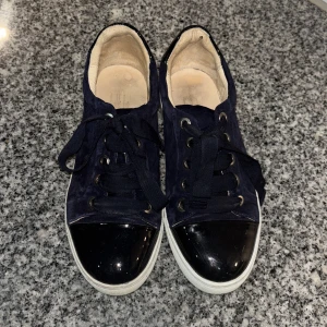 Mörkblå mockasneakers från Billi Bi - Snygga mörkblå sneakers från Billi Bi i mocka med svarta lackdetaljer på tå och häl. Skorna har vita sulor, rund tå och klassisk snörning. Ser exakt lika dana ut som lanvin skor. Har använts några få gånger. Köpta för 1500. Pris kan diskuteras!