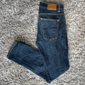 Nudie Jeans Grim Tim (Slim fit) Org. Dry Navy - Säljer nu dessa Nudie Jeans i den populära passformen Grim Tim | Använt men fortfarande i grymt skick (SE BILD) | Strl: W33 L32 | Färg: Org Dry Navy | Nypris: ~1400kr | Hör av dig vid minsta fundering :)