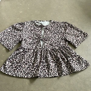 Leopard blus - En leopard mönstrad top som är öppen framtill med 2 snören som man knyter ihop.