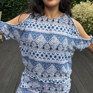 Mönstrade blå och vita topp - Säljer en topp med blått och vitt mönster. Toppen har avslappnad passform. Perfekta för varma dagar och ger en chill vibe med sitt unika print.