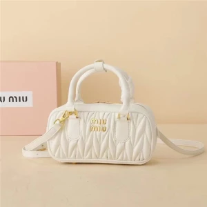 Vit quiltad handväska från Miu Miu - Supersnygg vit handväska från Miu Miu i quiltat skinn med guldiga detaljer och logga framtill. Väskan har både handtag och avtagbar axelrem. 