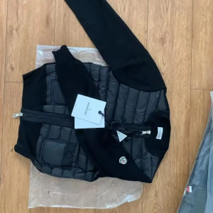 Svart quiltad cardigan jacka Moncler - Hejjj, nu säljer jag den populära moncler cardigan den är helt ny köpte den 2022 för 8499kr i NK den är äkta kvitto finns inga problem med den har aldrig använt den i storlek 1 som passar för XS och S