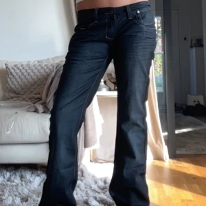 Svarta SWE jeans med nitar - Säljer ett par svarta jeans från SWE med snygga nitar på bakfickorna. Jeansen har raka ben, låg midja och kontrastsömmar. Midjemått: 39 cm, innerben: 85