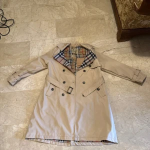 Beige trenchcoat burberry - Trenchcoat burberry har fått den som present så vet tyvärr inte om den är äkta. Anledningen till varför jag säljer den är för att den passar inte mig men den är helt ny oanvänd 
