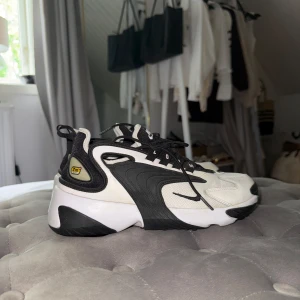 Nike Zoom 2K svartvita sneakers - Endast använda väldigt fåtal gånger som man ser på sulan under skon. 👟 är i storlek 40,5 men passar mig perfekt som i vanliga fall har 39 i skor.              Nike Zoom 2K sneakers i svart och vitt med chunky sula och cool retrodesign. Ovandel i mesh och syntet, tydliga loggor och snörning framtill. Skorna har en sportig vibe och passar perfekt till streetwear eller casual outfits.