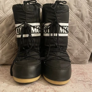 Moonboots - Säljer nu dessa höga svarta moonboots, dom är använda 1 vinter men ingenting mer! 😃  Dom är i storlek 41-45.               Finns tyvärr ingen skolåda till, eller kvitto! Hör av er vid frågor eller funderingar !🥳🤩