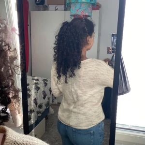 Beige stickad tröja med rund hals - Säljer en beige stickad tröja med rund halsringning och lång ärm. Tröjan har en avslappnad passform och är perfekt för lager-på-lager. Den är mjuk och lätt, vilket gör den skön att bära under kyligare dagar.