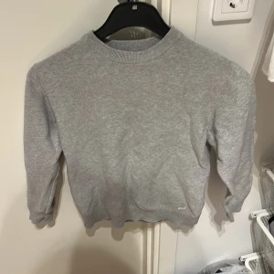 Grå basic sweatshirt i bomull - Enkel och stilren grå sweatshirt med rund hals och ribbade muddar. Perfekt för en chill look och funkar till det mesta. Mjuk och skön känsla tack vare bomullsmaterialet. Långärmad modell som är lätt att matcha med jeans eller joggers.