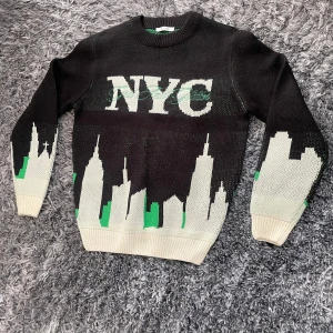 Only & sons stickad NYC-tröja - Cool svart stickad tröja med NYC-tryck över bröstet och en grafisk skyline i vitt och grönt längs nederkanten och ärmarna.  Pris kan diskuteras!