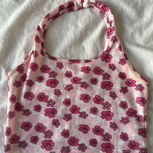 Blommig rosa linnetopp - Supersöt rosa linnetopp med stark rosa blommor över hela tyget. Toppen har halterneck och är ribbad. Perfekt för varma dagar och ger en riktigt somrig vibe! Köpt från shein och kommer inte mer till användning. Kontakta gärna innan köp!