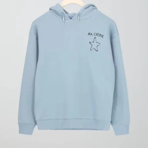Ljusblå hoodie med stjärna och text - Ljusblå hoodie med huva och snörning. På bröstet och ryggen finns svart broderad text 'MA CHÉRIE' och en stjärna. Tröjan har ribbade muddar och är långärmad. Perfekt för dig som gillar en chill och söt stil.