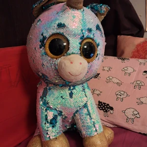 Stor enhörning som byter färg - Den är väldigt stor Byter färg Fint skick Dock är ögonen lite skrapade- men syns inte så mycket Den är från märket Ty och heter Dazzle Köpt för 550 kr   Kolla gärna in mina andra annonser för gruppsrabatt + samfrakt! 