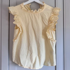 Gul blus med volang och spetsdetaljer - Supersöt ljusgul blus med volangprydda ärmar och halsringning.😍