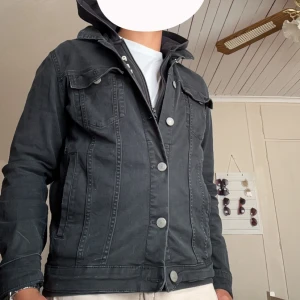 Svart jeansjacka från Jack & Jones - Svart jeansjacka från Jack & Jones med klassisk design, raka sömmar och silverfärgade knappar. Jackan har två bröstfickor med lock och knappar samt sidofickor. Perfekt för dig som vill ha en stilren och tidlös look. Skick 6.5/10