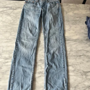 Levi's 511 ljusblå jeans W28 L32 - Säljer ett par klassiska Levi's 511 jeans i ljusblå denim. Modellen har en slim passform med raka ben och normal midja. Perfekta för dig som gillar en tidlös och avslappnad stil. Ikonisk läderpatch baktill och femficksdesign.