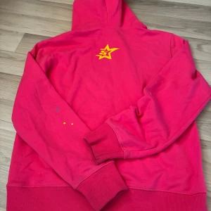 Rosa spider hoodie och byxor ( set) - Coola rosa mjukisbyxor och hoodie med huva och tryck framtill med spindelnät, texten 'Prak! nevermind the spider, here’s the slime' och små stjärnor i gult och blått. Mjuk bomullskänsla, långa ärmar och ribbade muddar. Perfekt för dig som gillar färg och statement-plagg.