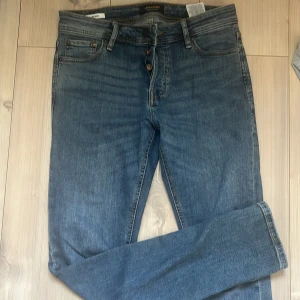 Blå jeans från Jack & Jones, strl 30/32 - Säljer nu ett par till av Jack&Jones stiliga jeans, Fint skick perfekt för dig som gillar en lite mer slim look men även vill ha ett par snygga byxor till ett lågt pris såklart!