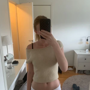 Beige stickad topp - Säljer denna jättefina beiga stickade toppen. Den kan bäras på många olika sätt vid halsringningen då den är stretchig. Kanten nertill är avklippt då den var mycket längre förut men den går lätt att vika upp! Hör av vid frågor💛💛