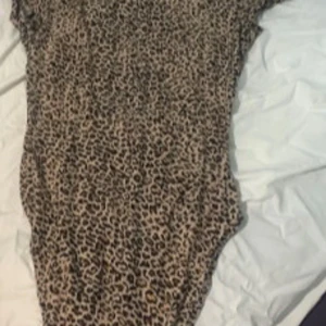 Leopardmönstrad mesh bodytopp från shien  - Säljer en snygg bodytopp i mesh med leopardmönster. Toppen har korta ärmar och är figurnära med rundad hals. Perfekt för dig som vill sticka ut med ett djurmönster och gillar trendiga detaljer.