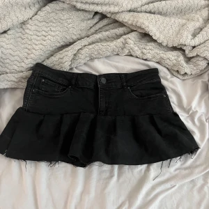 Svart jeanskjol med volang  - Jätte snygg lågmidjade jeans kjol med volang, 37 cm tvärs över, köpt för 350 och använd kanske 3 gånger, säljer då ja behöver pengar! Hör av dig vid funderingar💞