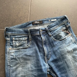 Replay Anbass blå jeans, storlek 32 - Säljer ett par snygga Replay Anbass jeans i  med snygga slitningar. Vid frågor är det bara att höra av sig!