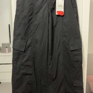 Svarta cargopants från Zara, stl S - Svarta cargopants från Zara i storlek S. Byxorna har bred passform, flera stora fickor på benen och är tillverkade i ett lätt bomullstyg. Perfekta för en avslappnad och trendig streetstil.
