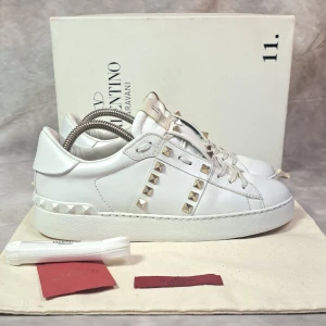 Valentino Open - Stl 37 - Vita Valentino Opens med guld nitar! | Mycket bra skick: 8,5/10, ytterst lite repade längst fram på skorna, inget man ser vid användning utan bara vid nära inspektion, 🙌 | Stl: 37 | Medföljer vid köp: Skorna, skobox, extra snörren och Valentino kort | Hör av dig vid frågor eller fler bilder | Mvh Galgen 