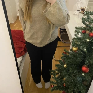 Svarta kostymbyxor med rak passform - Säljer ett par svarta kostymbyxor med rak passform och midwaist. Byxorna har klassisk look med hällor för bälte och diskret dragkedja framtill. Perfekta till en snygg stickad tröja eller skjorta. Stilrena och enkla att matcha.