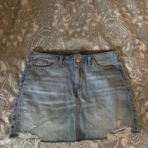 Blå jeanskjol med slitningar - Snygg ljusblå jeanskjol 