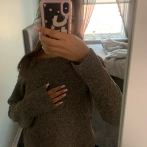 Brun stickad tröja med lång ärm - Mysig brun stickad tröja med lång ärm och rund hals. Perfekt för kyliga dagar och enkel att matcha med jeans eller leggings. Tröjan har en loose passform och är tillverkad i ett mjukt stickat material som känns skönt mot huden.