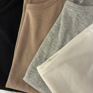 4-pack basic t-shirts Gina Tricot - Fyra basic t-shirts från Gina Tricot i storlek S. Färgerna är svart, beige, ljusgrå och vit. Alla har rund hals och korta ärmar, tillverkade i mjuk bomull.